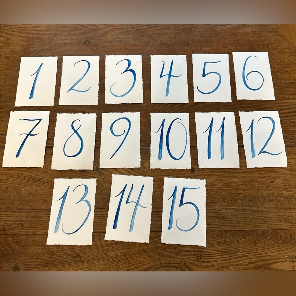 Hand drawn blue table numbers. Like new. Numbers 1 through 15.